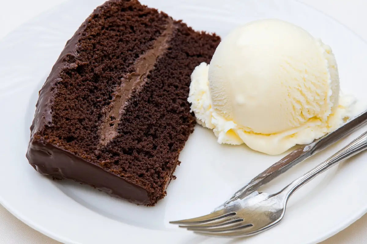 Chocolate pound cake slice with vanilla ice cream on a white plate